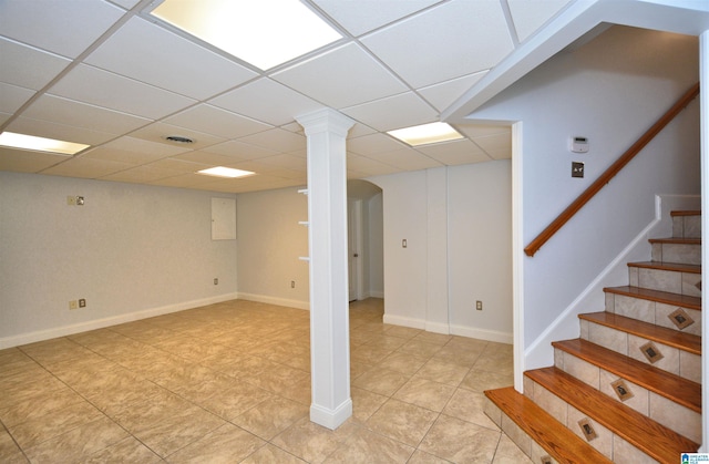 basement featuring a paneled ceiling and light tile patterned floors