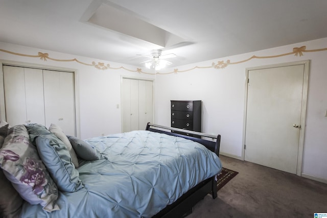 carpeted bedroom featuring ceiling fan and multiple closets