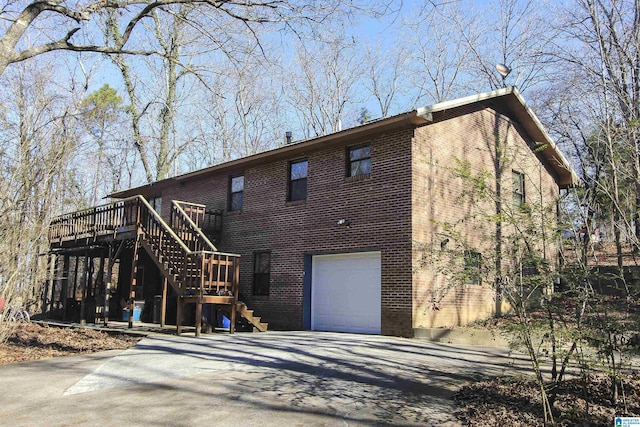 back of house featuring a garage and a deck