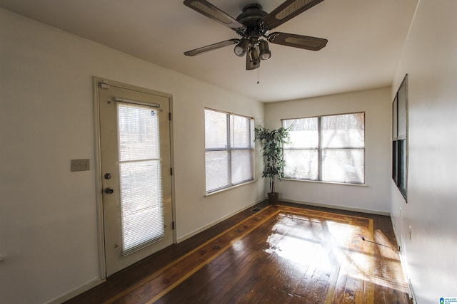 doorway to outside featuring ceiling fan and dark wood-type flooring