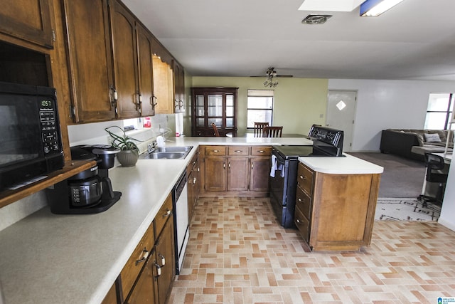 kitchen with black appliances, kitchen peninsula, and sink