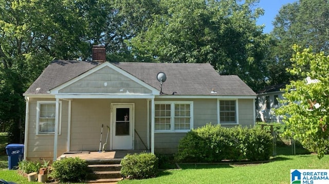 rear view of house featuring a yard