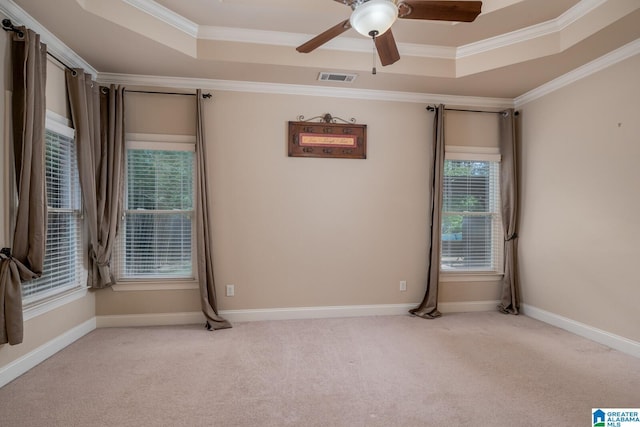 unfurnished room with light colored carpet, a raised ceiling, ceiling fan, and crown molding