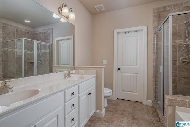 bathroom featuring tile patterned floors, vanity, toilet, and walk in shower