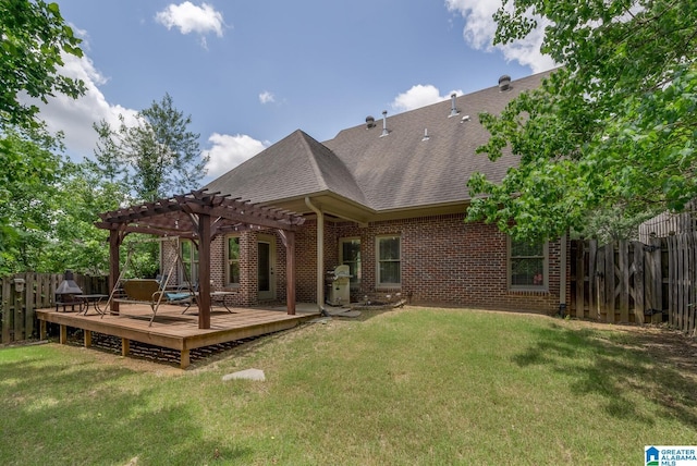 rear view of property with a pergola, a yard, and a deck