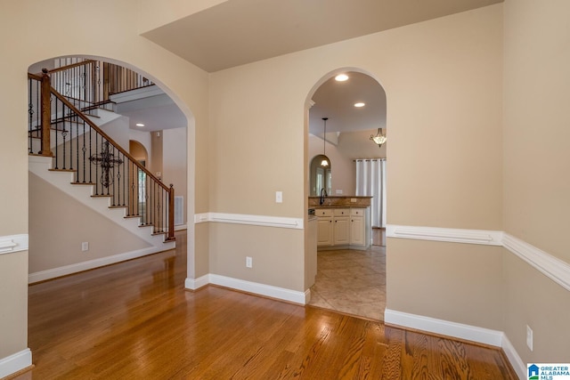 unfurnished room featuring sink and light hardwood / wood-style floors