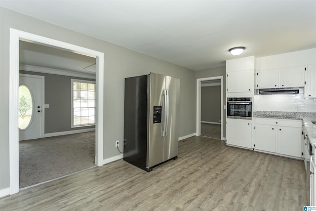 kitchen with decorative backsplash, light stone countertops, light carpet, stainless steel appliances, and white cabinets