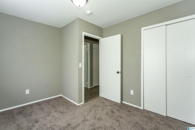 unfurnished bedroom with light colored carpet and a closet