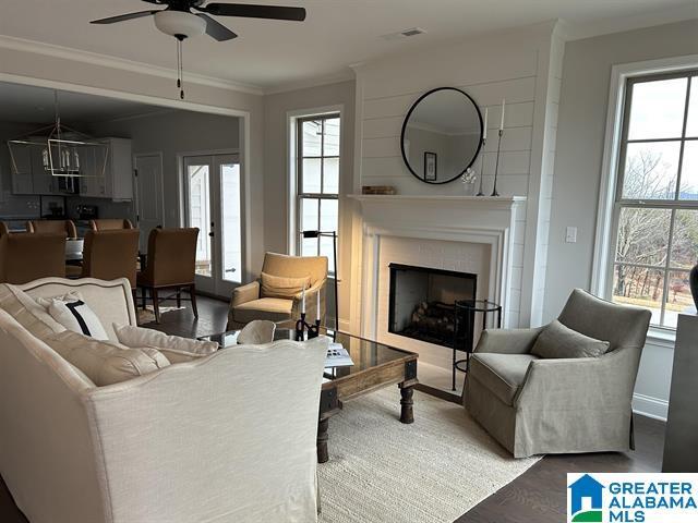 living room with hardwood / wood-style floors, plenty of natural light, ceiling fan, and crown molding