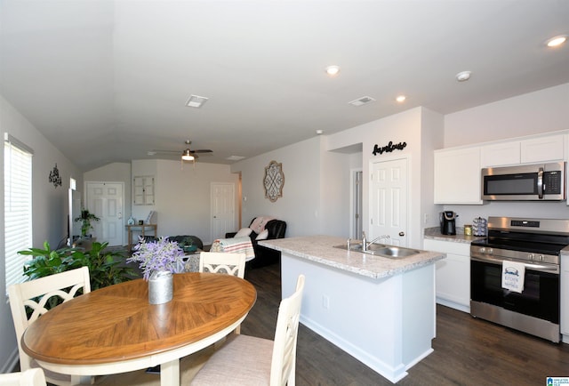 kitchen with stainless steel appliances, ceiling fan, a kitchen island with sink, sink, and white cabinetry