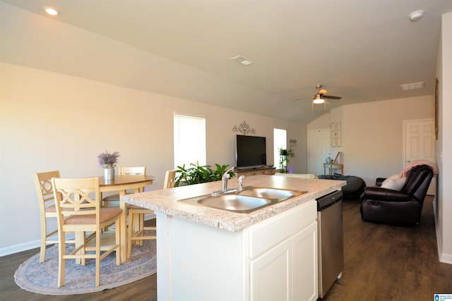 kitchen with ceiling fan, sink, dishwasher, white cabinetry, and an island with sink