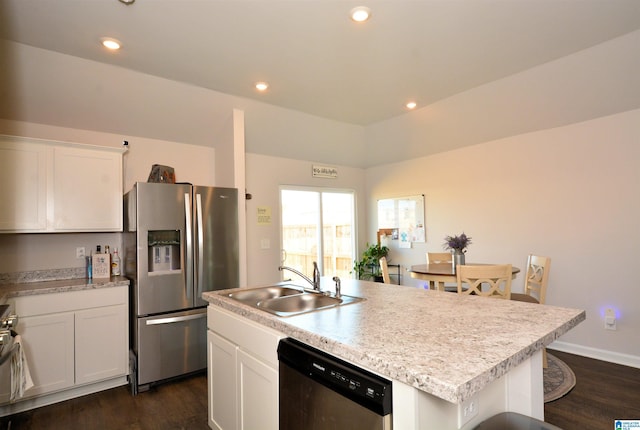 kitchen with white cabinets, sink, stainless steel appliances, and an island with sink