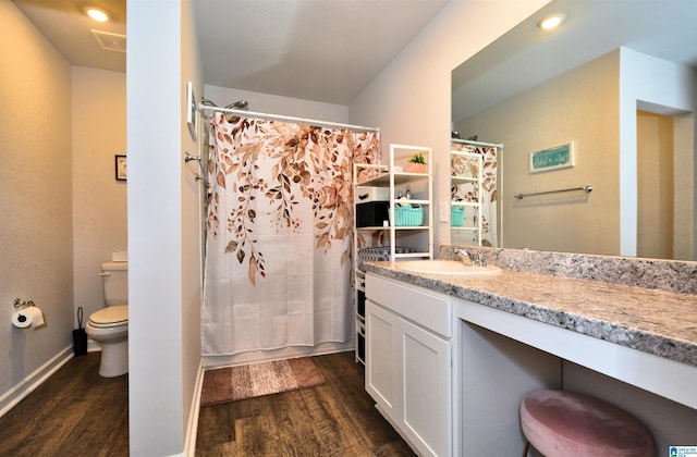 full bathroom with shower / bath combo with shower curtain, hardwood / wood-style floors, vanity, and toilet