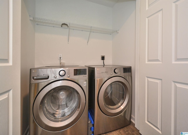 clothes washing area with washing machine and dryer and dark hardwood / wood-style floors