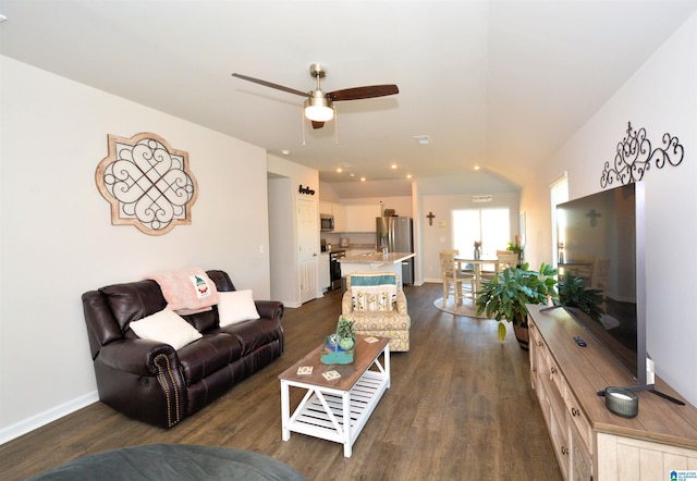 living room with ceiling fan and dark wood-type flooring