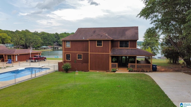 rear view of house with a yard and a water view