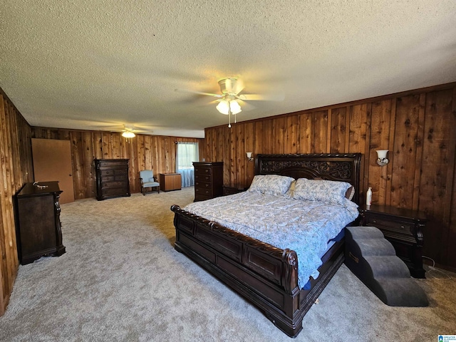 carpeted bedroom with a textured ceiling, ceiling fan, and wooden walls