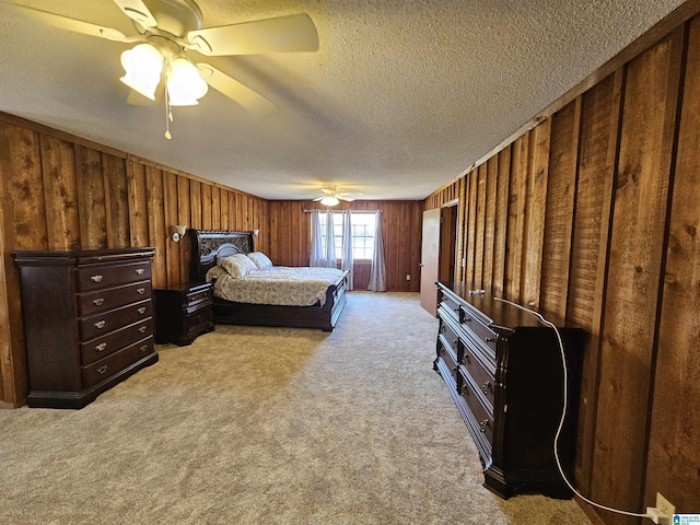 bedroom featuring a textured ceiling, ceiling fan, light carpet, and wooden walls