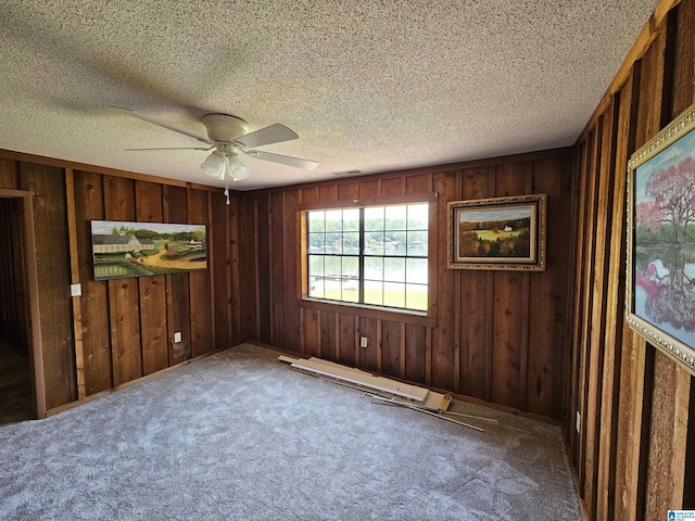 unfurnished bedroom featuring ceiling fan, carpet floors, and a textured ceiling