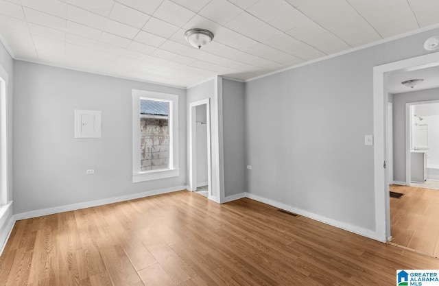 empty room featuring light hardwood / wood-style flooring and crown molding