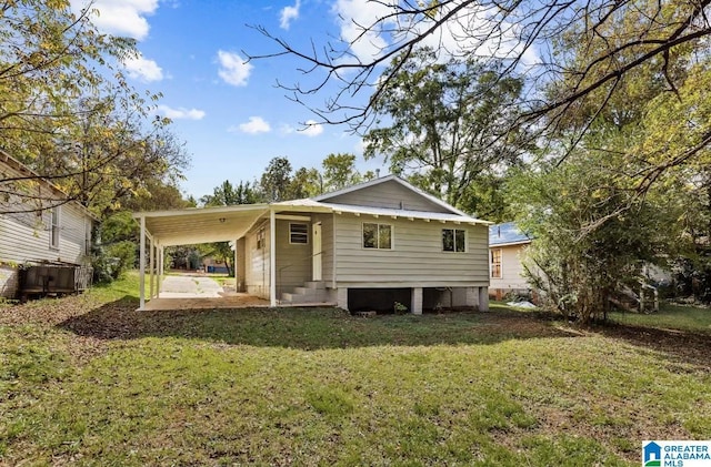 rear view of house with a carport and a lawn