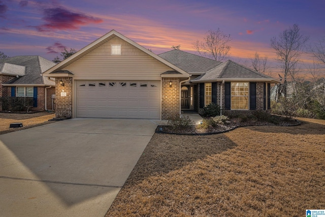 ranch-style house with a garage and a lawn