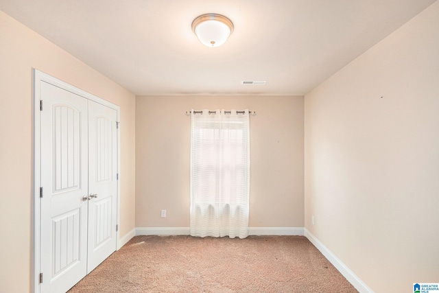 unfurnished bedroom with a closet and carpet flooring