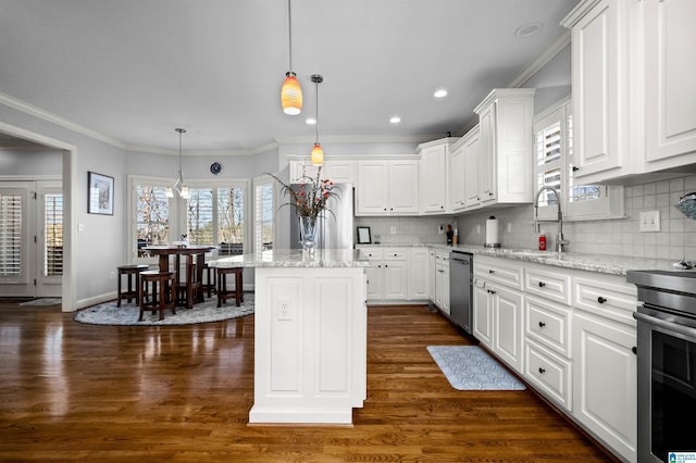 kitchen featuring a kitchen island, light stone countertops, white cabinetry, and hanging light fixtures