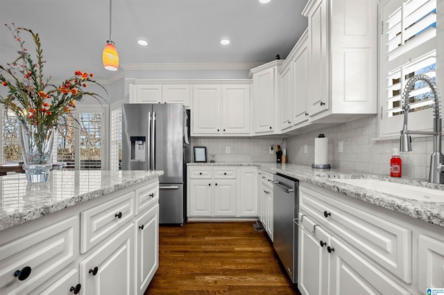 kitchen featuring dark hardwood / wood-style floors, white cabinets, stainless steel appliances, and decorative light fixtures