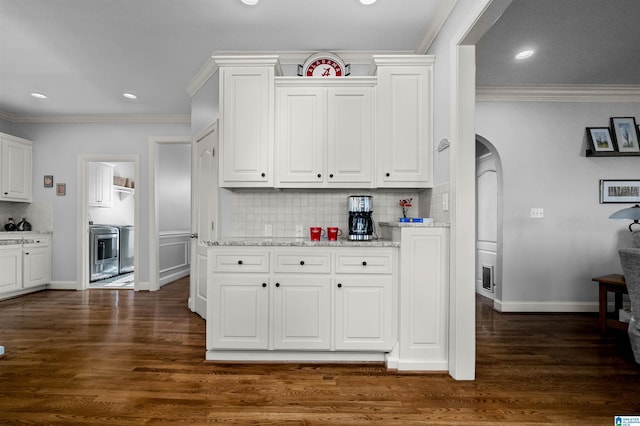 kitchen with dark wood-type flooring, decorative backsplash, light stone countertops, ornamental molding, and white cabinetry