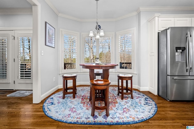 dining area featuring dark hardwood / wood-style flooring, crown molding, and a chandelier