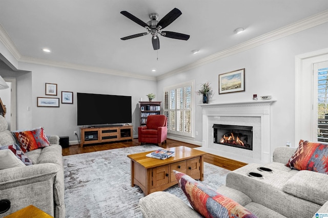 living room featuring hardwood / wood-style flooring, ceiling fan, and ornamental molding