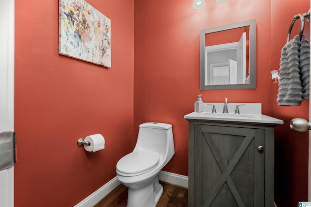 bathroom featuring vanity, wood-type flooring, and toilet