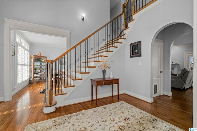 stairway with hardwood / wood-style floors and ornamental molding