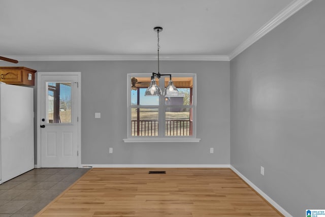 unfurnished dining area featuring ornamental molding, a wealth of natural light, a notable chandelier, and light tile patterned flooring