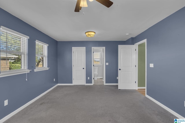 unfurnished bedroom featuring connected bathroom, ceiling fan, and light colored carpet