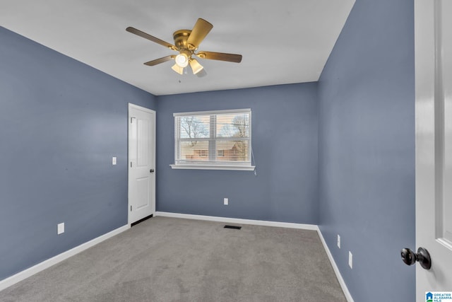 carpeted spare room featuring ceiling fan