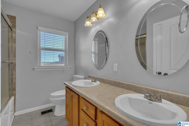 full bathroom featuring tile patterned floors, shower / bath combination with glass door, vanity, and toilet