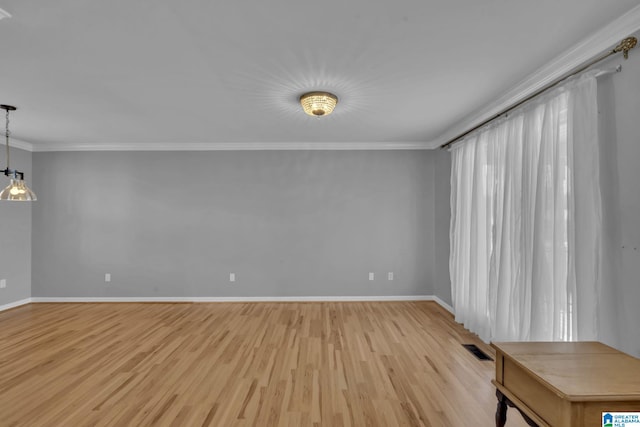 spare room featuring a chandelier, light hardwood / wood-style floors, and ornamental molding