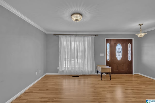 foyer featuring light hardwood / wood-style floors, an inviting chandelier, and ornamental molding