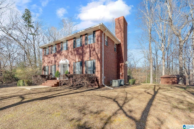 view of front of house with central AC unit and a storage shed