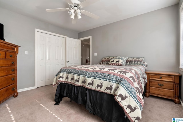 carpeted bedroom featuring ceiling fan and a closet