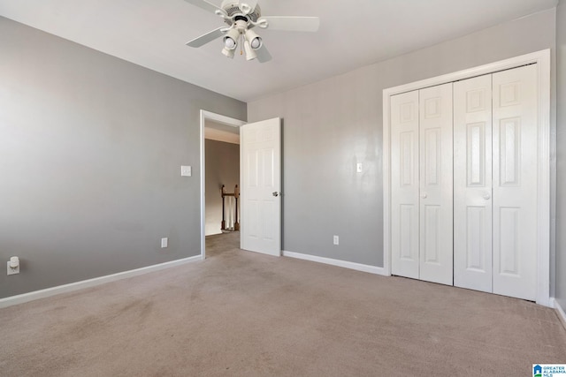 unfurnished bedroom with ceiling fan, light colored carpet, and a closet