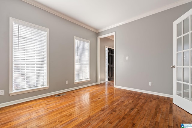 empty room with light hardwood / wood-style flooring and crown molding