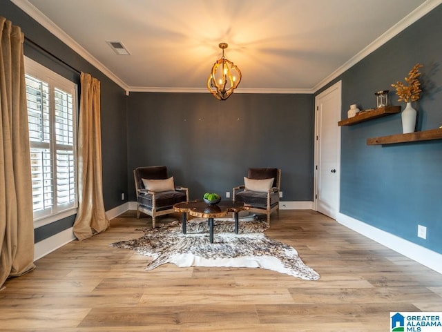 living area featuring ornamental molding, light hardwood / wood-style floors, and a notable chandelier