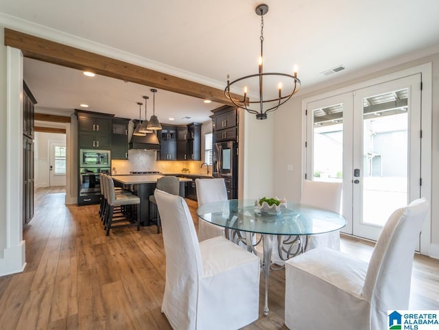 dining room featuring a healthy amount of sunlight, ornamental molding, and french doors