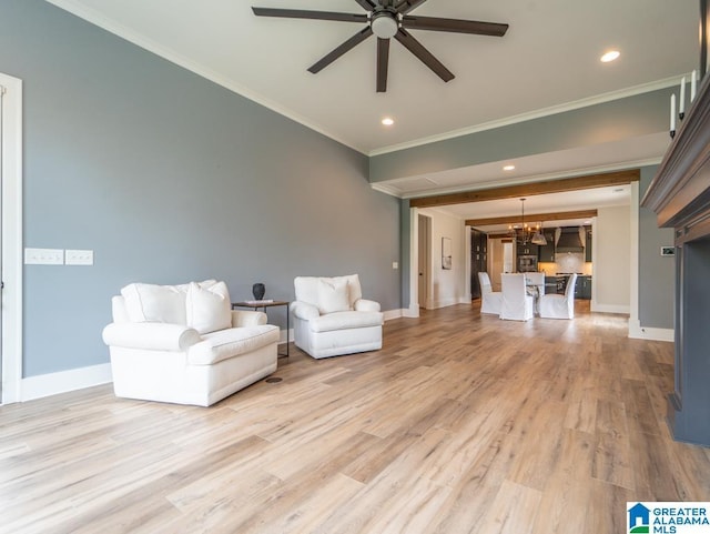 unfurnished living room featuring crown molding, light hardwood / wood-style flooring, and ceiling fan with notable chandelier