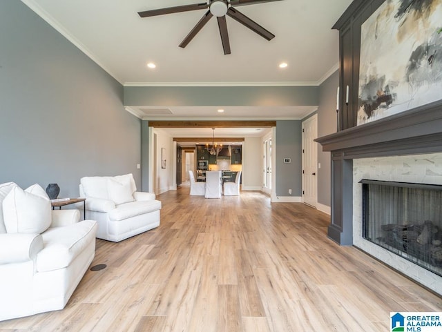 unfurnished living room with ceiling fan with notable chandelier, light hardwood / wood-style flooring, and ornamental molding