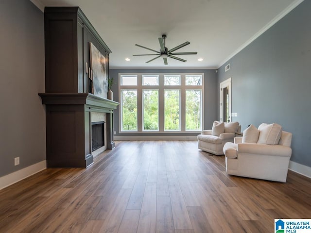 living room featuring ceiling fan, dark hardwood / wood-style flooring, and ornamental molding