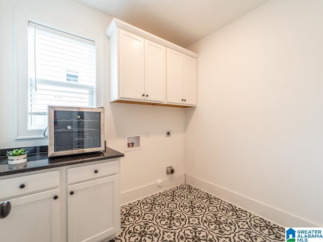 washroom with hookup for an electric dryer, washer hookup, cabinets, gas dryer hookup, and light tile patterned floors